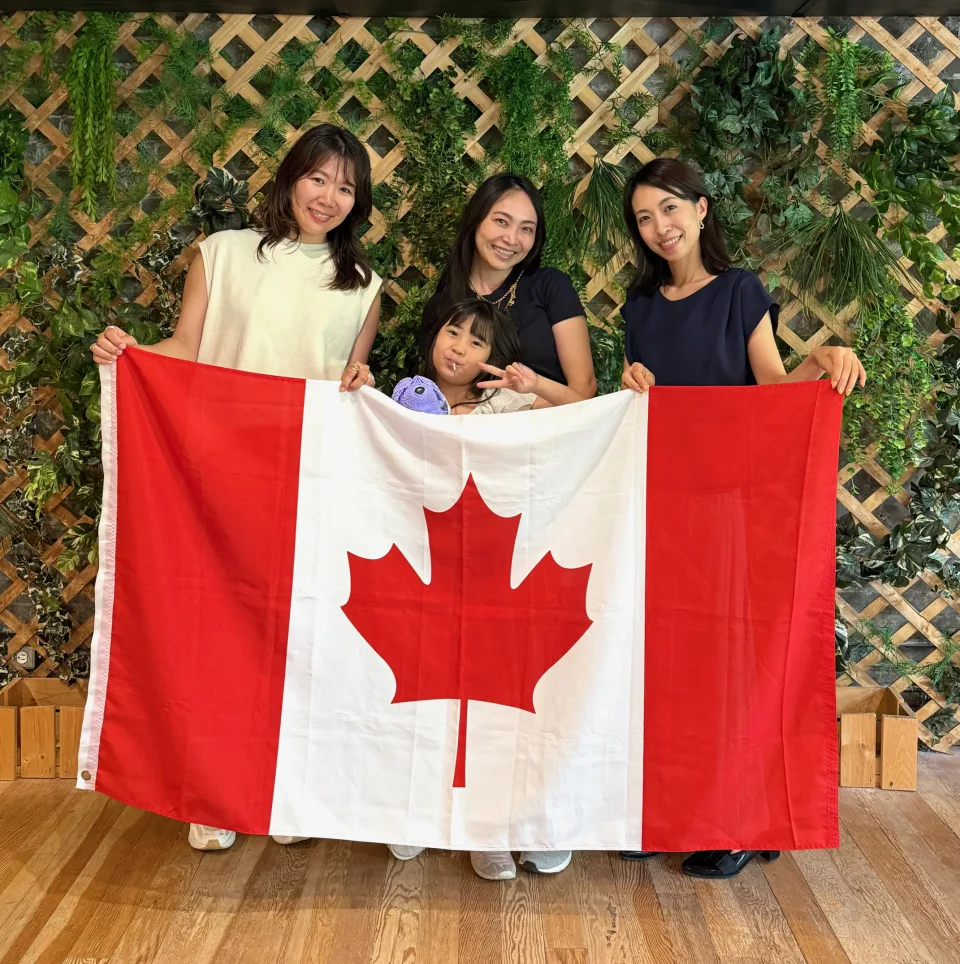 カナダ国旗を持って交流する家族と西岡彩